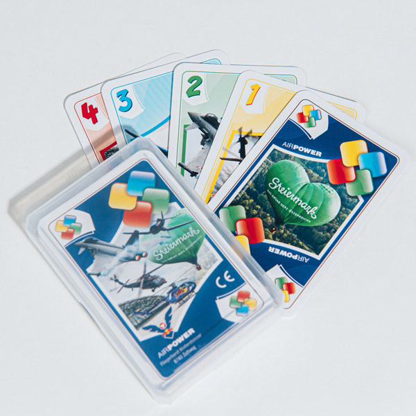 Kartenspielset mit verschiedenen Flugzeugen; geöffnete Hülle zeigt Karten mit Zahlen und bunten Symbolen.