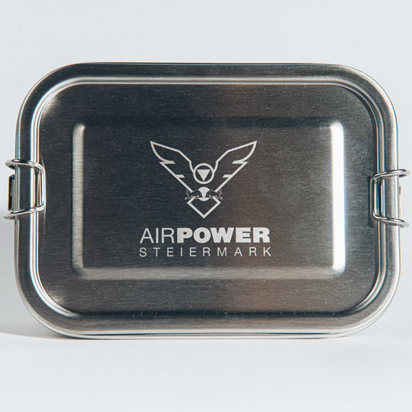 Rechteckige Metallbox mit geflügeltem Logo und dem Text „AIRPOWER STEIERMARK“ auf dem Deckel.