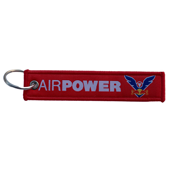 Roter Schlüsselanhänger mit der Aufschrift „AIRPOWER“ und blauem Adler-Logo auf der rechten Seite.